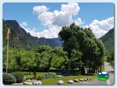 Parcela con vistas a la montaña, árboles y cielo despejado del Camping Cardós, Cardós Pirineus (Lleida)
