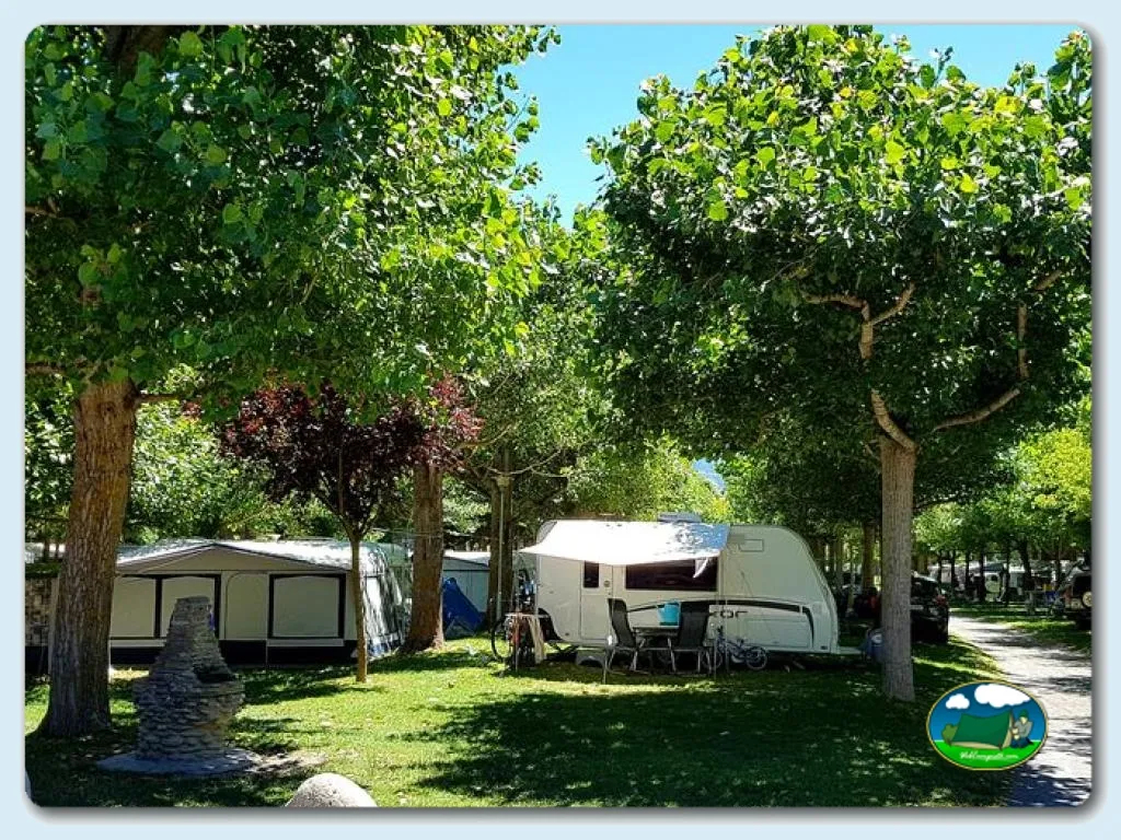 Parcela con mobil-home bajo árboles del Camping Cardós, Cardós Pirineus (Lleida)
