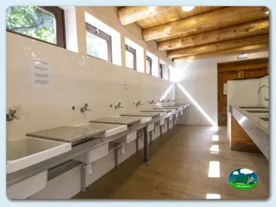 Aseos con lavabos y vigas de madera del Camping La Borda del Pubill, Ribera de Cardós (Lleida)