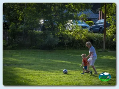 Parcela con zona de juegos infantiles rodeada de arboleda del Camping La Borda del Pubill, Ribera de Cardós (Lleida)