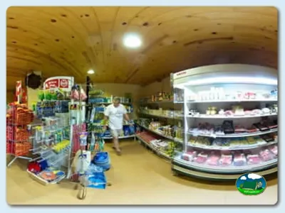 Supermercado interior con estanterías y vitrinas refrigeradas del Camping La Borda del Pubill, Ribera de Cardós (Lleida)