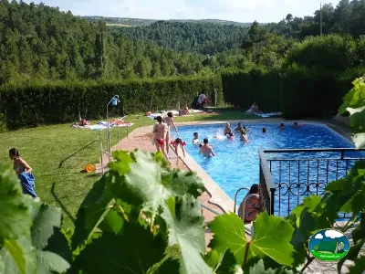 Piscina con vistas a la montaña, zona de juegos y césped del Camping Cal Paradis, Salo (Barcelona)