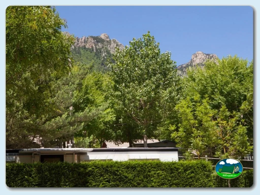 Montaña con parcelas arboladas y edificio del Camping Font Freda, Castellar del Riu (Barcelona)