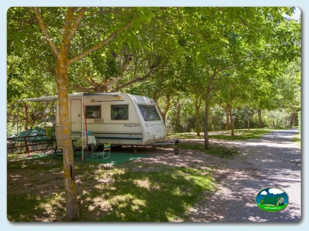 Mobil-home bajo arboleda con sombrilla del Camping Font Freda, Castellar del Riu (Barcelona)