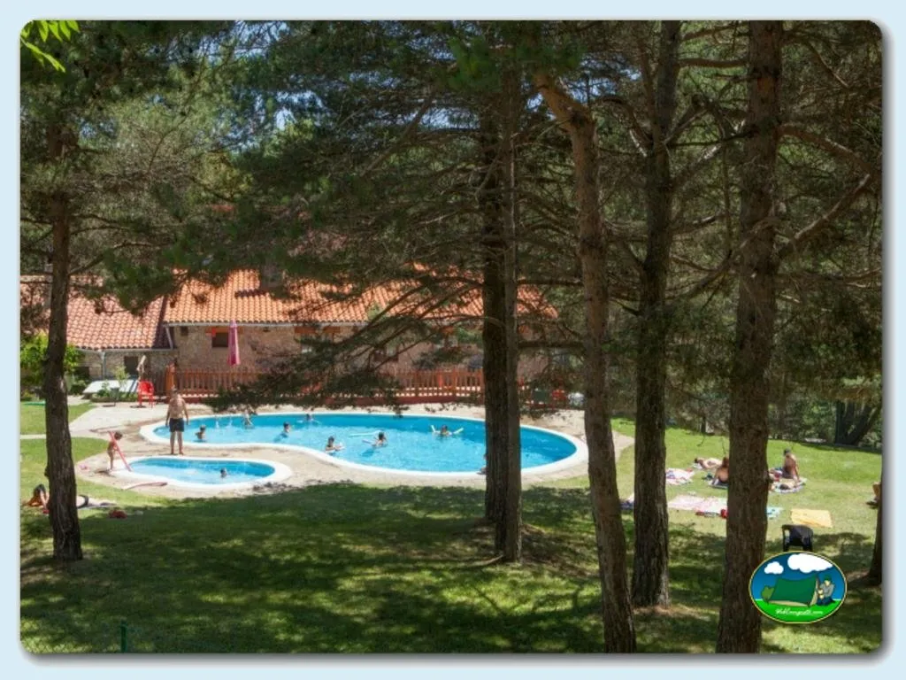 Piscina infantil con vistas a bungalow entre pinos del Camping Font Freda, Castellar del Riu (Barcelona)