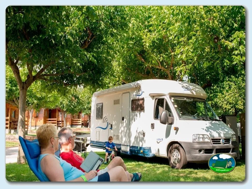 Mobil-home junto a árbol con familia del Camping Berga Resort, Berga (Barcelona)