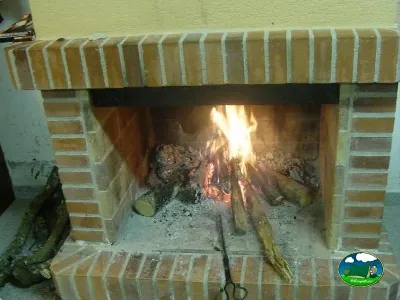Chimenea de ladrillo con fuego del Camping La Balma, Espinelves (Girona)