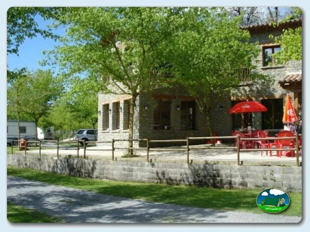 Restaurante con terraza y sombrillas rojas del Camping Rupit, Rupit (Barcelona)
