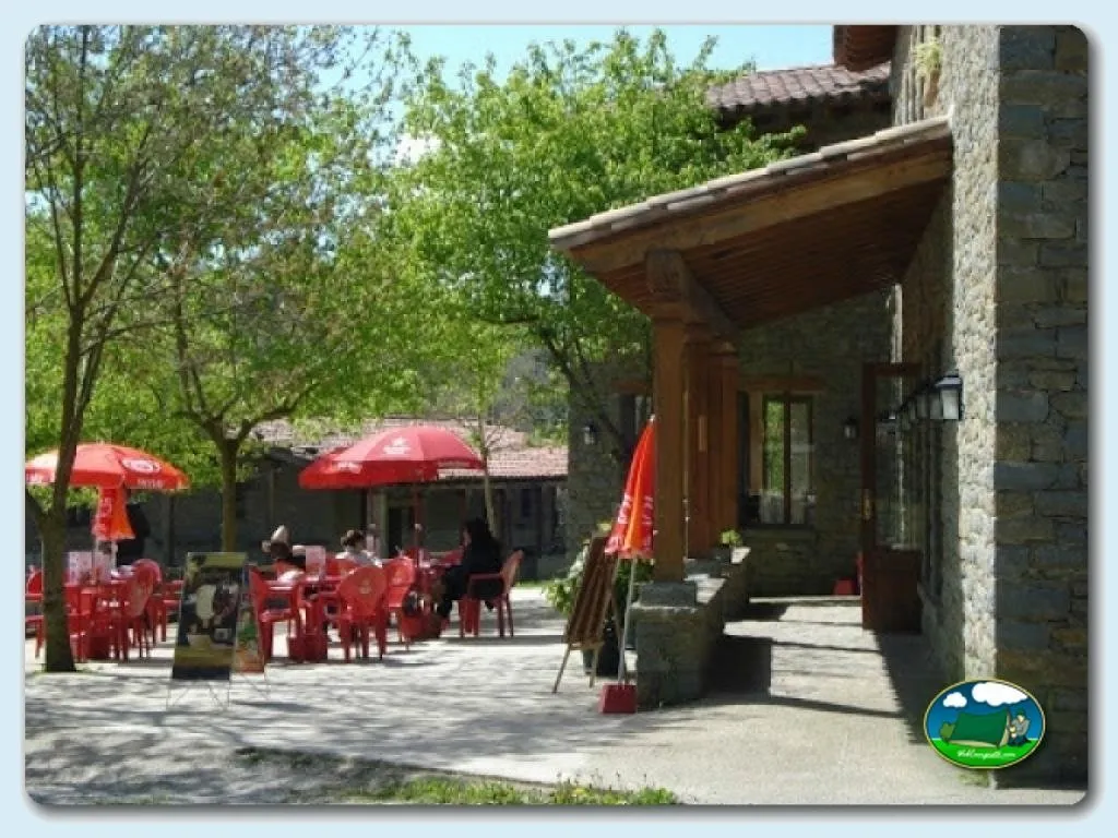 Restaurante con terraza y sombrillas rojas del Camping Rupit, Rupit (Barcelona)