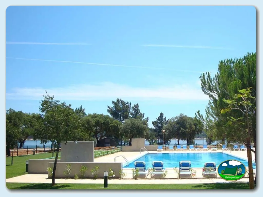 Piscina junto al lago con tumbonas y vistas al agua del Camping Orbitur Montargil, Montargil (Portalegre)