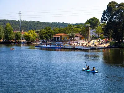 Río con playa y actividades acuáticas, montaña al fondo del Camping Ortiga, Ortiga (Santarém)