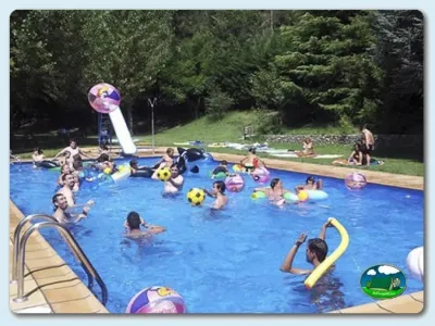 Piscina infantil llena de niños con tobogán y juegos acuáticos del Camping Pont D'Ardaix, Aristot (Lleida)