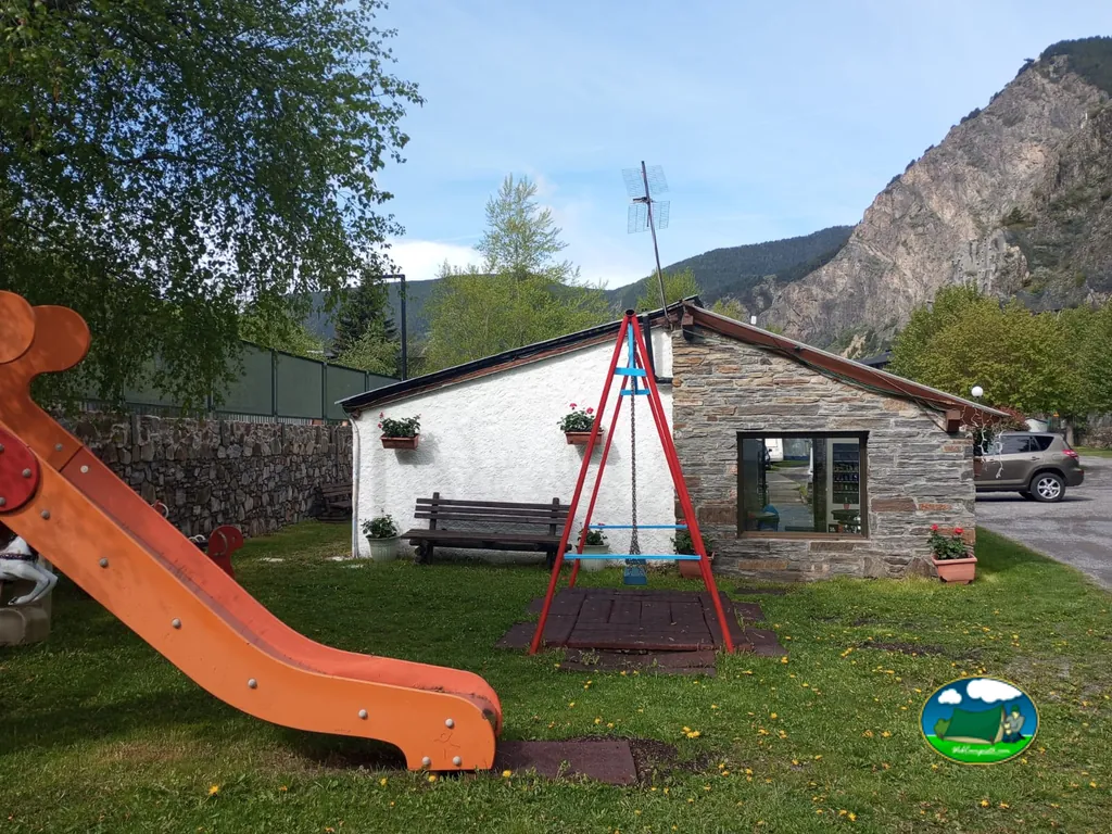 Parque infantil del Camping Casal con la montaña de Canillo al fondo