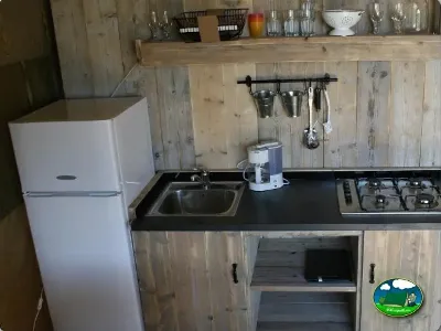 Cocina de glamping con estufa y refrigerador del Camping Lloret Blau, Lloret de Mar (Girona)