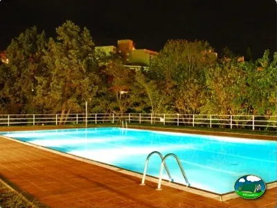 Piscina climatizada nocturna con vistas a la montaña del Camping Lloret Blau, Lloret de Mar (Girona)