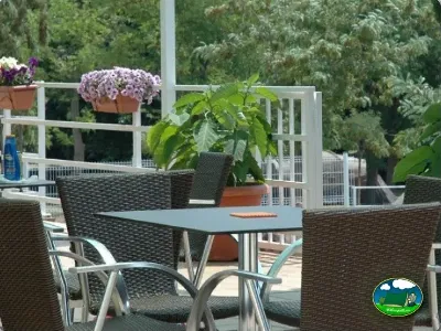 Terraza con vistas a la montaña, flores y mobiliario de jardín del Camping Lloret Blau, Lloret de Mar (Girona)