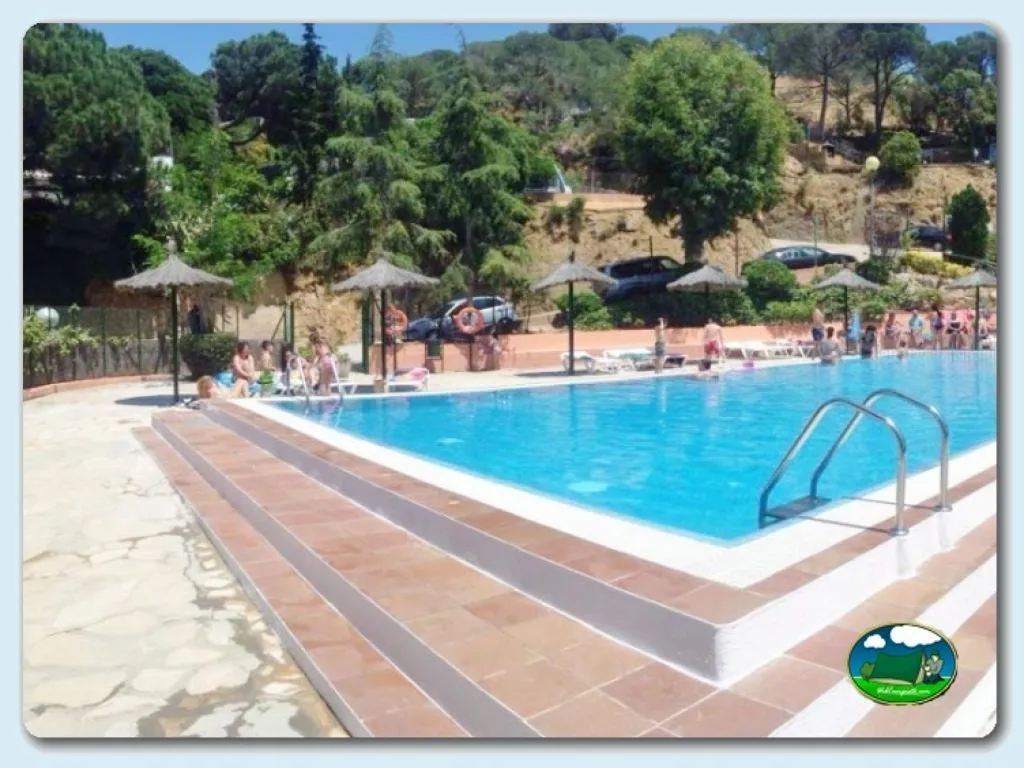 Piscina con vistas a la montaña y sombrillas del Camping Cala Canyelles, Lloret de Mar (Girona)