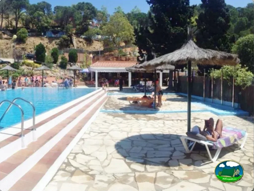 Piscina con zona de playa y sombrillas del Camping Cala Canyelles, Lloret de Mar (Girona)