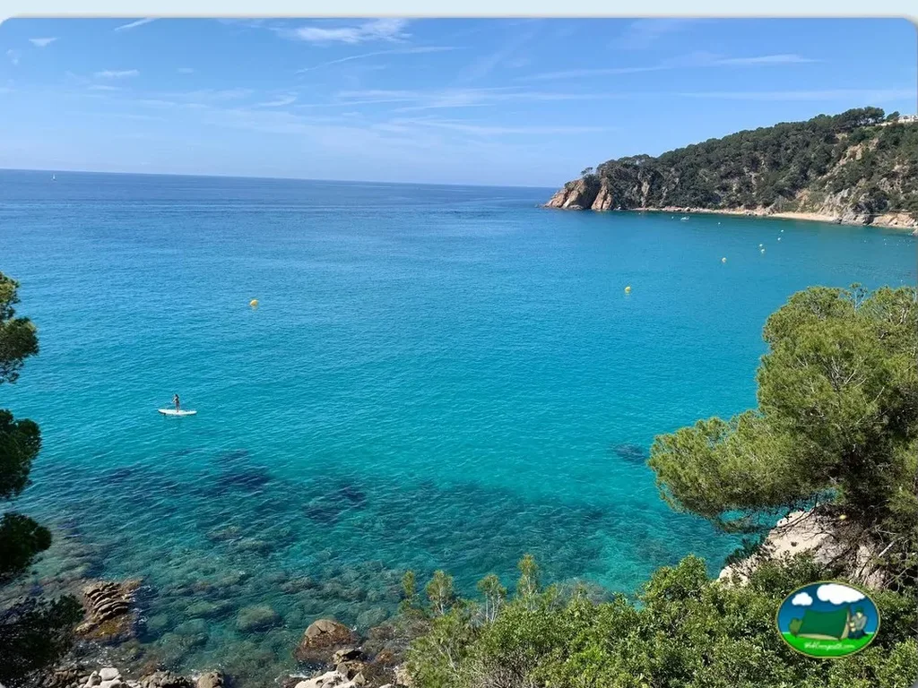 Playa junto al mar con aguas turquesas y acantilado del Camping Cala Llevadó, Tossa de Mar (Girona)