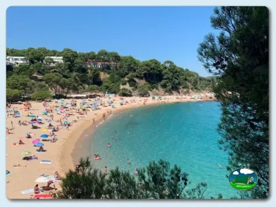 Playa junto al mar con aguas turquesas y bungalows en acantilado del Camping Vall D`Or, Platja d'Aro (Girona)