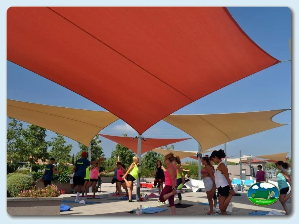 Actividad infantil bajo sombrillas en el recinto del Camping Riembau, Playa de Aro (Girona)