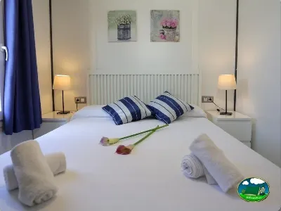 Bungalow dormitorio con cama matrimonial y toallas del Camping Eurocamping, Sant Antoni de Calonge (Girona)