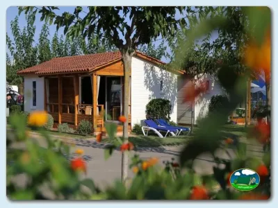 Bungalow con porche y tumbonas, rodeado de árboles del Camping Eurocamping, Sant Antoni de Calonge (Girona)