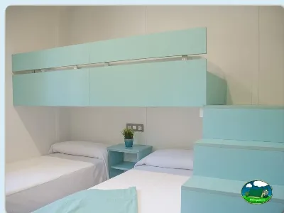 Mobil-home con literas y diseño moderno en tonos turquesa del Camping Eurocamping, Sant Antoni de Calonge (Girona)