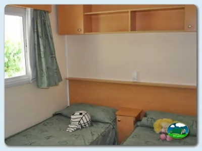 Mobil-home interior con camas y armarios del Camping Mas Patoxas, Pals (Girona)