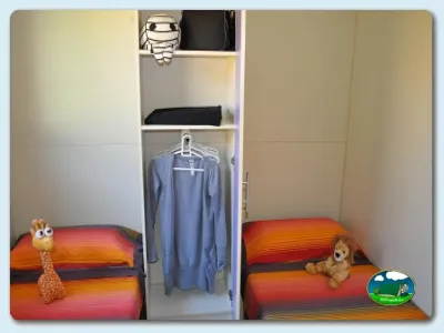Bungalow interior con dos camas y armario del Camping Mas Patoxas, Pals (Girona)