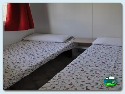 Mobil-home interior con dos camas del Camping Mas Patoxas, Pals (Girona)