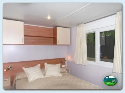 Mobil-home interior con cama doble y armarios del Camping Mas Patoxas, Pals (Girona)