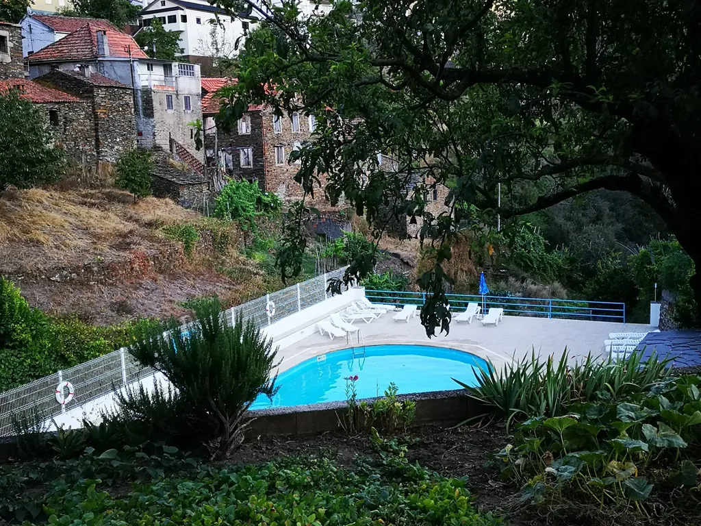 Piscina con vistas a la montaña y arquitectura rural del Camping Parque da Bica, Pomares (Coimbra)