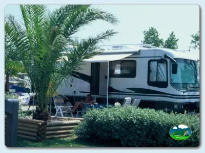 Mobil-home con terraza y sombrilla en parcela arbolada del Camping Las Dunas, Sant Pere Pescador (Girona)