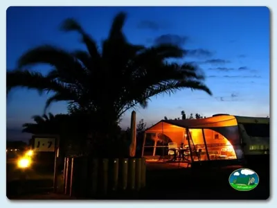 Glamping iluminado al atardecer con palmera del Camping Las Dunas, Sant Pere Pescador (Girona)