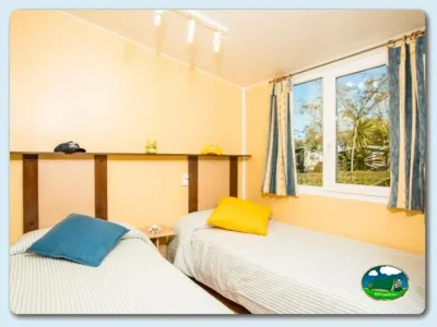 Mobil-home interior con dos camas y vistas al jardín del Camping Las Dunas, Sant Pere Pescador (Girona)