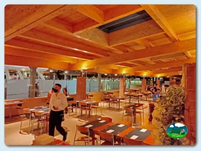 Restaurante con vigas de madera y zona de comedor del Camping Las Dunas, Sant Pere Pescador (Girona)