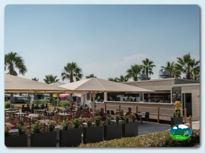 Restaurante con terraza y vistas a palmeras del Camping Las Dunas, Sant Pere Pescador (Girona)