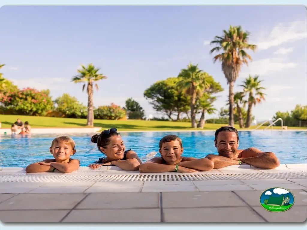 Piscina con familia disfrutando, palmeras y jardín del Camping Paradis, L'Escala (Girona)