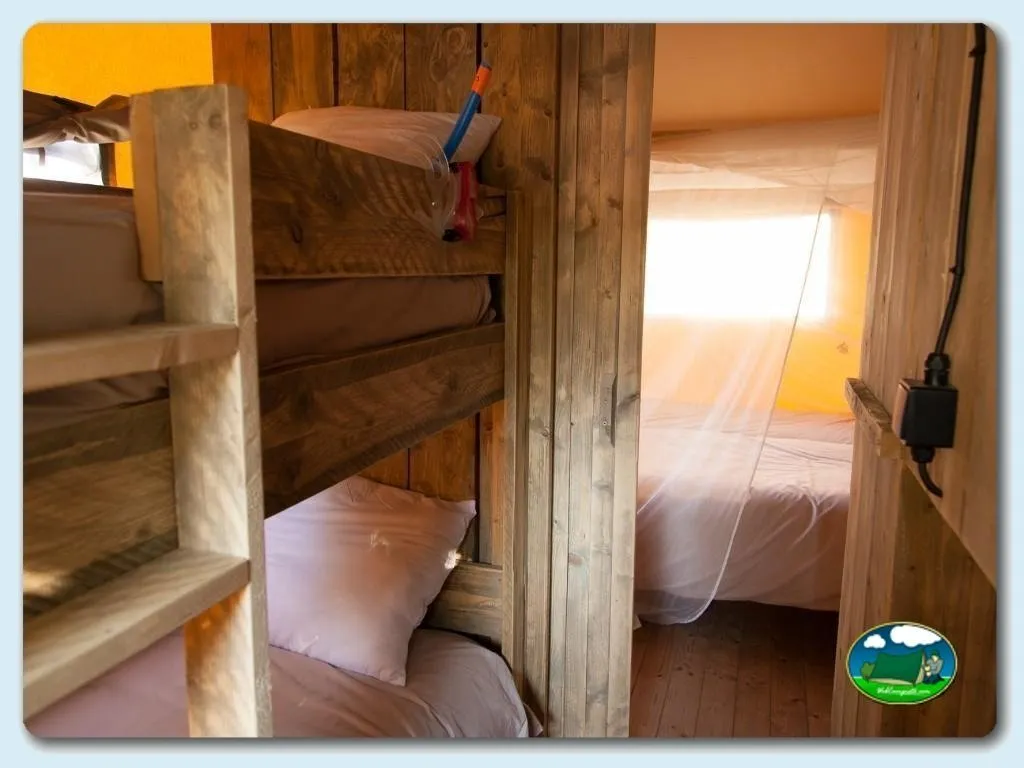 Cabaña interior con camas y literas de madera del Camping Riu, Sant Pere Pescador (Girona)