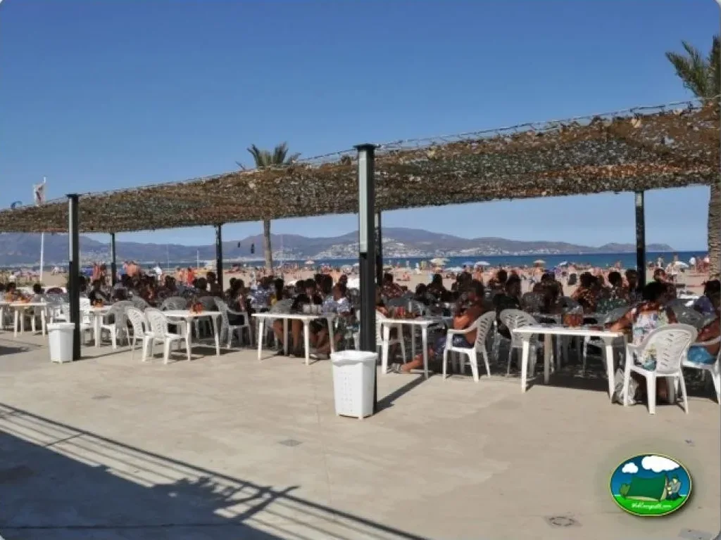 Playa junto al mar con bar y vistas a la montaña del Camping Nautic Almata, Castelló d'Empúries (Girona)