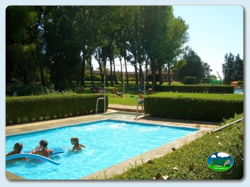 Piscina con niños, jardín arbolado y zona de esparcimiento del Camping El Bolaso, Ejea de los Caballeros (Zaragoza)