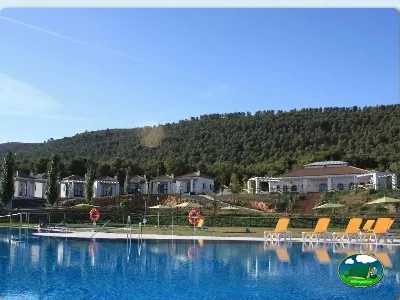 Piscina con vistas a la montaña, bungalows y tumbonas del Camping La Sierrecilla, Humilladero (Málaga)