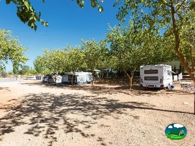 Parcela con mobil-home bajo árboles del Camping La Sierrecilla, Humilladero (Málaga)