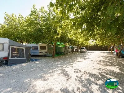 Parcela con mobil-home bajo árboles del Camping La Sierrecilla, Humilladero (Málaga)