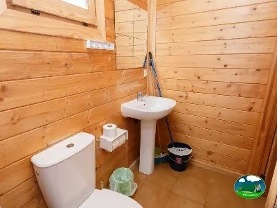Aseos de cabaña de madera con lavabo y váter del Camping La Sierrecilla, Humilladero (Málaga)