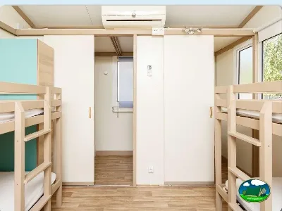 Mobil-home interior con litera de madera y aire acondicionado del Camping La Sierrecilla, Humilladero (Málaga)