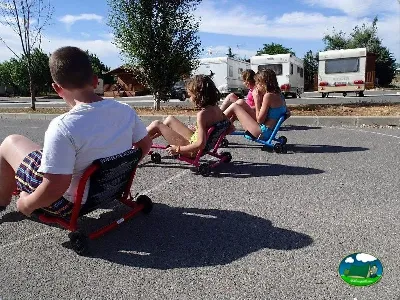 Niños jugando en patinetes en parcela del Camping La Sierrecilla, Humilladero (Málaga)
