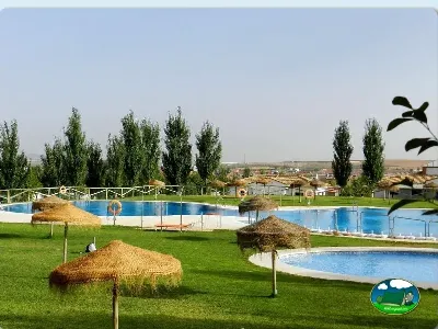 Piscina con vistas a la llanura y árboles de álamo del Camping La Sierrecilla, Humilladero (Málaga)