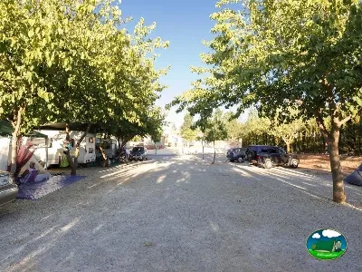 Parcela con vehículos y arbolado del Camping La Sierrecilla, Humilladero (Málaga)